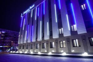 een gebouw met blauwe en paarse lichten erop bij Renion Park Hotel in Alma-Ata