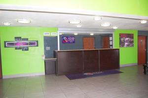 a lobby with green walls and a desk and a door at Stay Express Inn Dallas - Fair Park / Downtown in Dallas