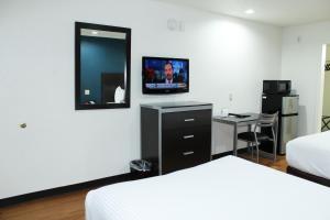 a hotel room with two beds and a flat screen tv at Stay Express Inn Dallas - Fair Park / Downtown in Dallas