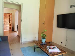 a living room with a coffee table and a flat screen tv at Kington Guest Suite in Pretoria