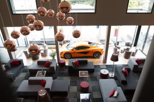 フランコルシャンにあるホテル デ ラ ソースのソファ付きの客室にオレンジ色の車が駐車しています。