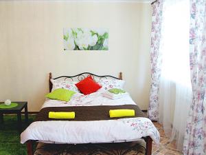 een slaapkamer met een bed met rode en groene kussens bij Bestshome Apartment 3 in Bisjkek