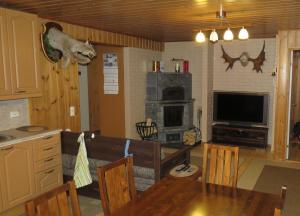 a living room with a dining room table and a kitchen at Mannimaatila Uni Lux in Punkaharju