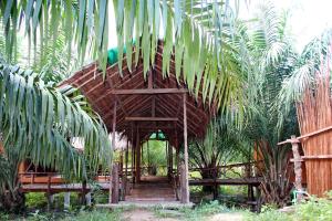un edificio in bambù con un sentiero in legno in una foresta di YaoIsland Resort and Farm a Ko Yao Yai