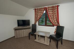 a room with a table and two chairs and a television at Complex Craiasa Muntilor Moieciu in Moieciu de Sus