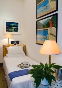 
a hotel room with a bed, desk and a painting on the wall at Hotel Locanda Cairoli in Rome
