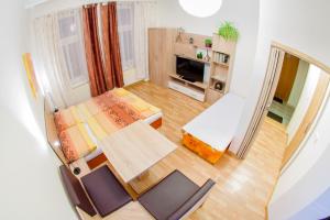 a small room with a bed and a table and chairs at Apartment Centrum in České Budějovice