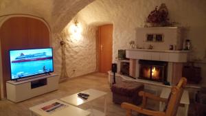 ein Wohnzimmer mit einem TV und einem Kamin in der Unterkunft Kloesterle in Bad Steben