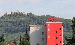 un edificio rojo con un cartel de hotel encima en San Marco, en Montecchio Maggiore