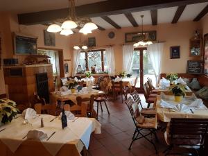ein Restaurant mit Tischen und Stühlen mit weißem Tischtuch in der Unterkunft Landgasthof zum Brückenwirt in Starnberg