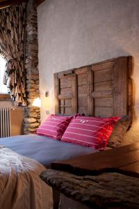 a bedroom with a large bed with a wooden headboard at Il Fienile della Nonna in Introd