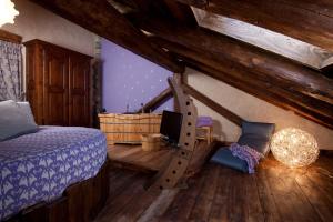 Il Fienile della Nonna في إينترود: غرفة نوم بسرير وتلفزيون على أرضية خشبية