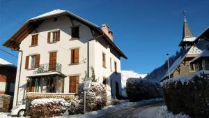 a white house in the snow with a church at Les Cristaux in Saint-Gervais-les-Bains