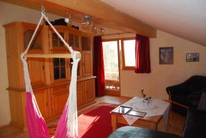 a living room with a hammock hanging from the ceiling at Ferienwohnung Familie Schweiger in Ramsau