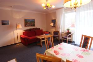 a living room with a red couch and a table at Residenz Albatros in Cuxhaven +9 photos