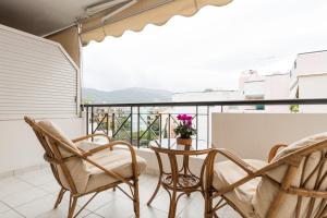 a balcony with chairs and a table and a view at Holargos Metro Rooms in Athens