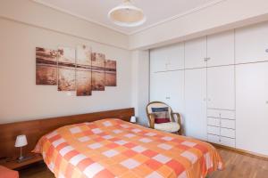 a bedroom with a bed and some pictures on the wall at Holargos Metro Rooms in Athens