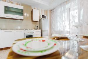 トリヤッチにあるКВАРТИРНОЕ БЮРО Апартаменты на Кудашева 110のキッチン(テーブル、皿付)
