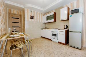 トリヤッチにあるКВАРТИРНОЕ БЮРО Апартаменты на Кудашева 110のキッチン(テーブル、白い冷蔵庫付)