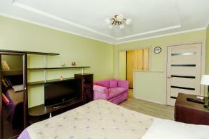 トリヤッチにあるКВАРТИРНОЕ БЮРО Апартаменты на Кудашева 110のリビングルーム(ベッド1台、ピンクのソファ付)