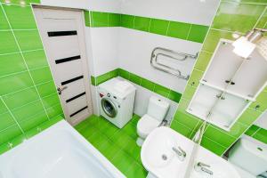 トリヤッチにあるКВАРТИРНОЕ БЮРО Апартаменты на Кудашева 110の緑豊かなバスルーム(洗面台、洗濯機付)