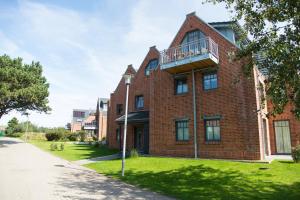 a red brick building with a balcony on a street at Living-art in Wangerooge