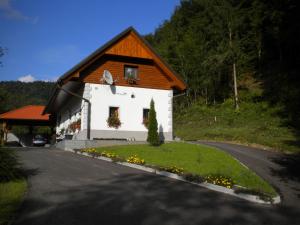 a small white building with a brown roof at Domačija Vodnik & Apartments in Cerklje na Gorenjskem