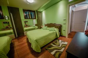 1 dormitorio con paredes verdes y 1 cama con sábanas verdes en Appartamenti Luxury Arco en Arco