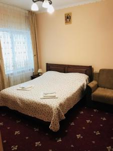a bedroom with a bed and a chair at Amfora Hotel in Nakonechnoye