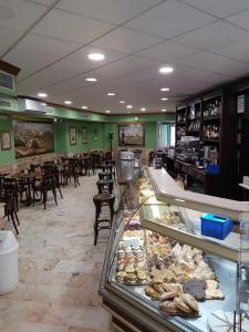 un restaurant avec une boulangerie dotée de tables et de chaises dans l'établissement Hotel San Pedro, à Carmona