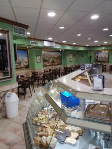 a fast food restaurant with a counter with pastries at Hotel San Pedro in Carmona