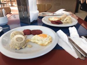 two plates of breakfast food on a table at Hotel Las Caobas in San Francisco de Macorís