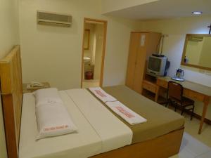 a hotel room with a bed and a desk and a television at Cebuview Tourist Inn in Cebu City