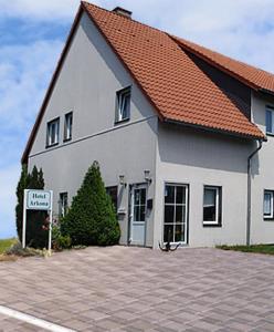 a large white house with a sign in front of it at Hotel Arkona in Genthin