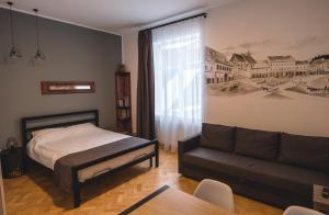 un dormitorio con una cama y un sofá en Zinne Apartments, en Brasov