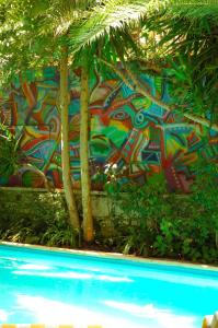 a wall with graffiti on it next to a swimming pool at Le Windsor, Jungle Art Hotel in Nice