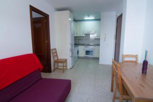 アルガロボ・コスタにあるAura Apartment Playaのリビングルーム(ソファ、テーブル付)、キッチンが備わります。