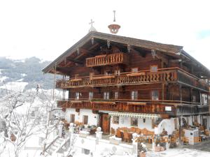a large wooden building in the snow at Talhof in Jochberg