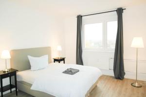 ペーネミュンデにあるSunny Apartment IIのベッドルーム(白いベッド1台、大きな窓付)