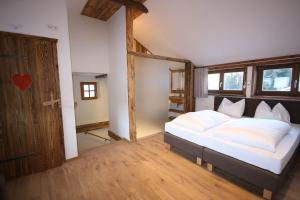 1 dormitorio con 1 cama grande y puerta de madera en Appartementhaus Brunnenhof, en Wagrain