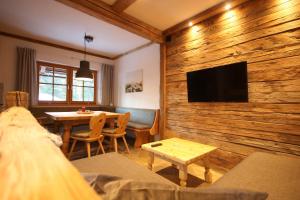 a living room with a wooden wall with a flat screen tv at Appartementhaus Brunnenhof in Wagrain