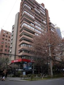 Un edificio alto con gente caminando frente a él. en CentriK Location Apartments Encomenderos 200, en Santiago