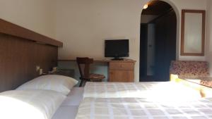 1 Schlafzimmer mit 2 Betten und einem Schreibtisch mit einem TV in der Unterkunft Gasthof Lechner in Oberrasen