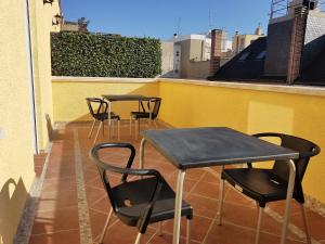 una fila de mesas y sillas en un balcón en Avenida De America Tijcal en Madrid