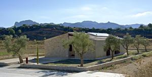 ein Gebäude mit Bäumen und Bergen im Hintergrund in der Unterkunft Casa Oryza in Arnés