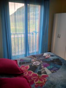 a bedroom with a bed with a window with blue curtains at Apartamento La Gloria in Gibaja