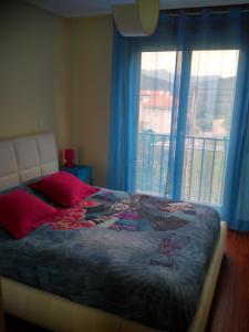 a bedroom with a bed and a window with a balcony at Apartamento La Gloria in Gibaja