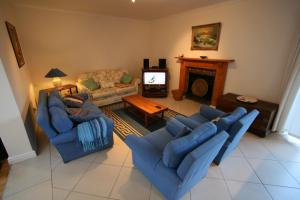 sala de estar con 2 sofás azules y chimenea en Home on Plato, en Plettenberg Bay