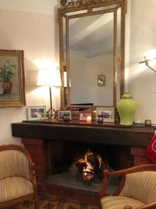 - un salon avec une cheminée et un grand miroir dans l'établissement Aniane Maison Renovee avec Jardin et Boulodrome, à Aniane