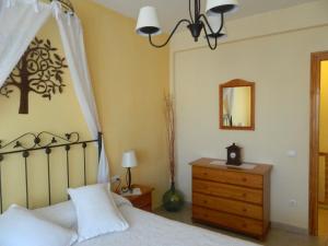 1 dormitorio con cama, tocador y espejo en Casa Rural El Boyo, en Mingorría
